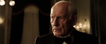 Movie still from “The Young and Prodigious T.S. Spivet” (2013), directed by Jean-Pierre Jeunet – An old man in a suit and bow tie looking into the distance; Close Up shot, Low angle