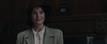 Movie still from “Their Finest” (2016), directed by Lone Scherfig – A woman wearing a brown hat and a beige jacket; Close Up shot, Over the shoulder angle