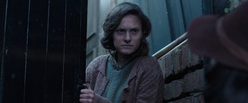 Movie still from “Their Finest” (2016), directed by Lone Scherfig – A woman standing on the steps of a building; Medium shot, Low angle