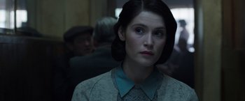 Movie still from “Their Finest” (2016), directed by Lone Scherfig – A woman in a blue shirt is looking to her left; Close Up shot, Over the shoulder angle