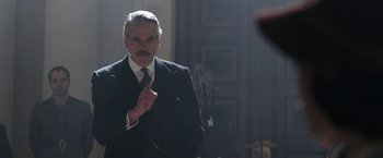 Movie still from “Their Finest” (2016), directed by Lone Scherfig – An older man wearing a suit and tie in front of a mirror; Close Up shot, Over the shoulder angle