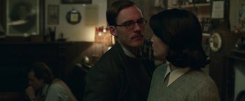 Movie still from “Their Finest” (2016), directed by Lone Scherfig – A man and a woman standing next to each other in a room; Close Up shot, Over the shoulder angle