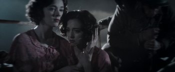 Movie still from “Their Finest” (2016), directed by Lone Scherfig – A woman in a pink dress is holding her hair; Close Up shot, Low angle
