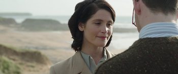 Movie still from “Their Finest” (2016), directed by Lone Scherfig – A person wearing a coat; Close Up shot, Over the shoulder angle
