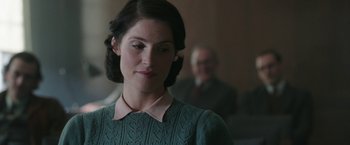 Movie still from “Their Finest” (2016), directed by Lone Scherfig – A woman in a green sweater looking to her left; Close Up shot, Over the shoulder angle
