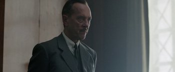 Movie still from “Their Finest” (2016), directed by Lone Scherfig – A man in a suit and tie looking to his left; Close Up shot, Low angle
