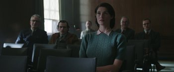 Movie still from “Their Finest” (2016), directed by Lone Scherfig – A woman in a green dress is looking at the camera; Medium shot, Over the shoulder angle