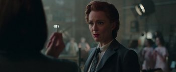 Movie still from “Their Finest” (2016), directed by Lone Scherfig – A woman in a suit and tie holding a cigarette in her hand; Close Up shot, Over the shoulder angle
