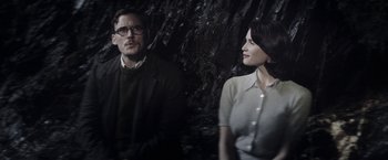 Movie still from “Their Finest” (2016), directed by Lone Scherfig – A man and a woman standing next to each other in front of trees; Medium shot, Over the shoulder angle