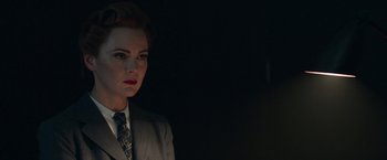Movie still from “Their Finest” (2016), directed by Lone Scherfig – A woman wearing a suit and tie standing in a dark room; Close Up shot, Low angle
