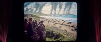 Movie still from “Their Finest” (2016), directed by Lone Scherfig – A group of people standing on top of a hill; Extreme Wide shot, High angle