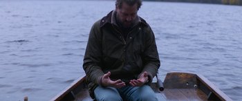Movie still from “Thelma” (2017), directed by Joachim Trier – A man sitting on a boat in the water; Medium shot, High angle