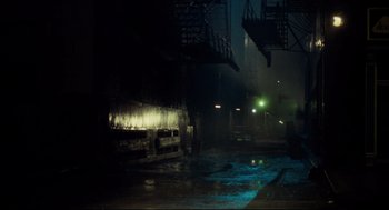 Movie still from “Thief” (1981), directed by Michael Mann – A city street at night in the rain with lights on; Extreme Wide shot, High angle