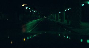 Movie still from “Thief” (1981), directed by Michael Mann – A view from a car of a street at night; Extreme Wide shot, High angle