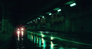 Movie still from “Thief” (1981), directed by Michael Mann – A car driving down a wet street at night; Extreme Wide shot, Low angle