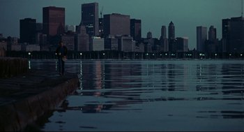 Movie still from “Thief” (1981), directed by Michael Mann – A man standing on a boat in a body of water at night; Extreme Wide shot, Over the shoulder angle