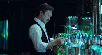 Movie still from “Thief” (1981), directed by Michael Mann – A man standing at a bar preparing a drink; Medium shot, Low angle