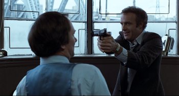 Movie still from “Thief” (1981), directed by Michael Mann – A man holding a gun up to another man's face; Medium shot, Over the shoulder angle