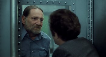 Movie still from “Thief” (1981), directed by Michael Mann – A man looking at himself in the mirror in front of a mirror; Close Up shot, Over the shoulder angle