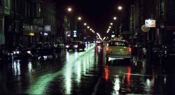 Movie still from “Thief” (1981), directed by Michael Mann – A city street at night lit up by streetlights; Extreme Wide shot, High angle