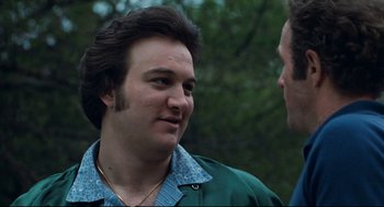 Movie still from “Thief” (1981), directed by Michael Mann – A man in a green jacket talking to another man in a green jacket; Close Up shot, Over the shoulder angle