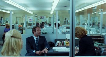 Movie still from “Thief” (1981), directed by Michael Mann – A man and a woman are sitting in an office; Medium shot, Over the shoulder angle