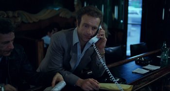 Movie still from “Thief” (1981), directed by Michael Mann – A man sitting at a table talking on a phone; Medium shot, Low angle