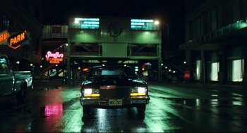 Movie still from “Thief” (1981), directed by Michael Mann – A car is driving down the street at night; Extreme Wide shot, Low angle
