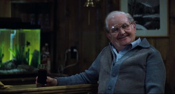 Movie still from “Thief” (1981), directed by Michael Mann – An older man sitting at a bar holding a drink; Close Up shot, Low angle