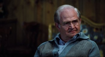 Movie still from “Thief” (1981), directed by Michael Mann – An older man wearing glasses and wearing a jacket; Close Up shot, Over the shoulder angle