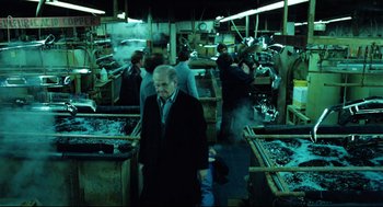 Movie still from “Thief” (1981), directed by Michael Mann – A group of people working in an assembly line; Wide shot, High angle