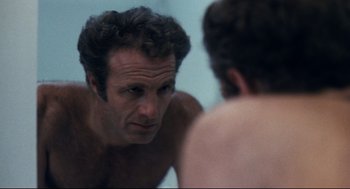 Movie still from “Thief” (1981), directed by Michael Mann – A man looking at himself in the mirror in front of a mirror; Close Up shot, Over the shoulder angle