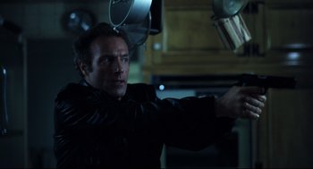 Movie still from “Thief” (1981), directed by Michael Mann – A man in a black jacket is holding a gun; Medium shot, Low angle