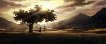 Two people standing under a tree in the middle of a field