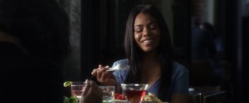 Movie still from “Think Like a Man” (2012), directed by Tim Story – A woman sitting at a table with a plate in front of her; Close Up shot, Over the shoulder angle