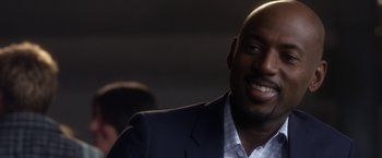 Movie still from “Think Like a Man” (2012), directed by Tim Story – A person wearing a suit and smiling; Close Up shot, Over the shoulder angle