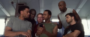 Movie still from “Think Like a Man” (2012), directed by Tim Story – A group of men looking at a cell phone; Medium shot, Low angle