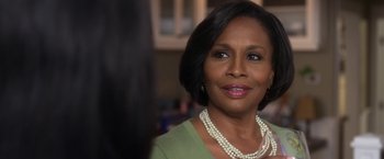 Movie still from “Think Like a Man” (2012), directed by Tim Story – An older woman wearing a green shirt and a pearl necklace; Close Up shot, Over the shoulder angle