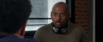 Movie still from “Think Like a Man” (2012), directed by Tim Story – A man with a beard wearing headphones and looking at the camera; Close Up shot, Over the shoulder angle