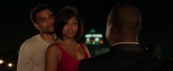 Movie still from “Think Like a Man” (2012), directed by Tim Story – A woman in a red dress standing next to a man in a black suit; Medium shot, Over the shoulder angle