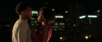 Movie still from “Think Like a Man” (2012), directed by Tim Story – A man and a woman standing next to each other in front of a city skyline at night; Medium shot, Over the shoulder angle