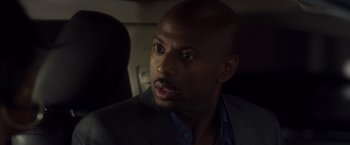 Movie still from “Think Like a Man” (2012), directed by Tim Story – A man in a gray suit and blue dress shirt; Close Up shot, Over the shoulder angle