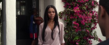 Movie still from “Think Like a Man” (2012), directed by Tim Story – A woman standing in front of a building with flowers; Medium shot, Over the shoulder angle