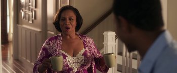 Movie still from “Think Like a Man” (2012), directed by Tim Story – An older woman holding two coffee cups in front of a mirror; Medium shot, Over the shoulder angle