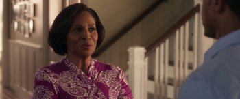 Movie still from “Think Like a Man” (2012), directed by Tim Story – An older woman wearing a pink shirt standing in front of a staircase; Close Up shot, Over the shoulder angle