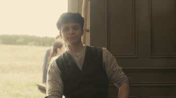 Movie still from “Anne with an E” (2017), created by Moira Walley-Beckett – A young man standing in front of a building; Medium shot, Low angle