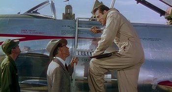 Movie still from “This Island Earth” (1955), directed by Joseph M. Newman – A man in a suit and hat standing next to a man in a hat; Medium shot, Low angle