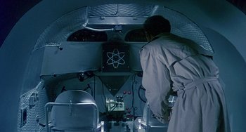Movie still from “This Island Earth” (1955), directed by Joseph M. Newman – A man standing inside of an airplane looking into the cockpit; Medium shot, Overhead angle