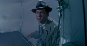 Movie still from “This Island Earth” (1955), directed by Joseph M. Newman – A man wearing a hat and a suit and tie; Medium shot, Low angle