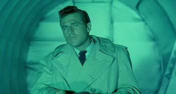 Movie still from “This Island Earth” (1955), directed by Joseph M. Newman – A man wearing a trench coat and tie; Medium shot, Low angle